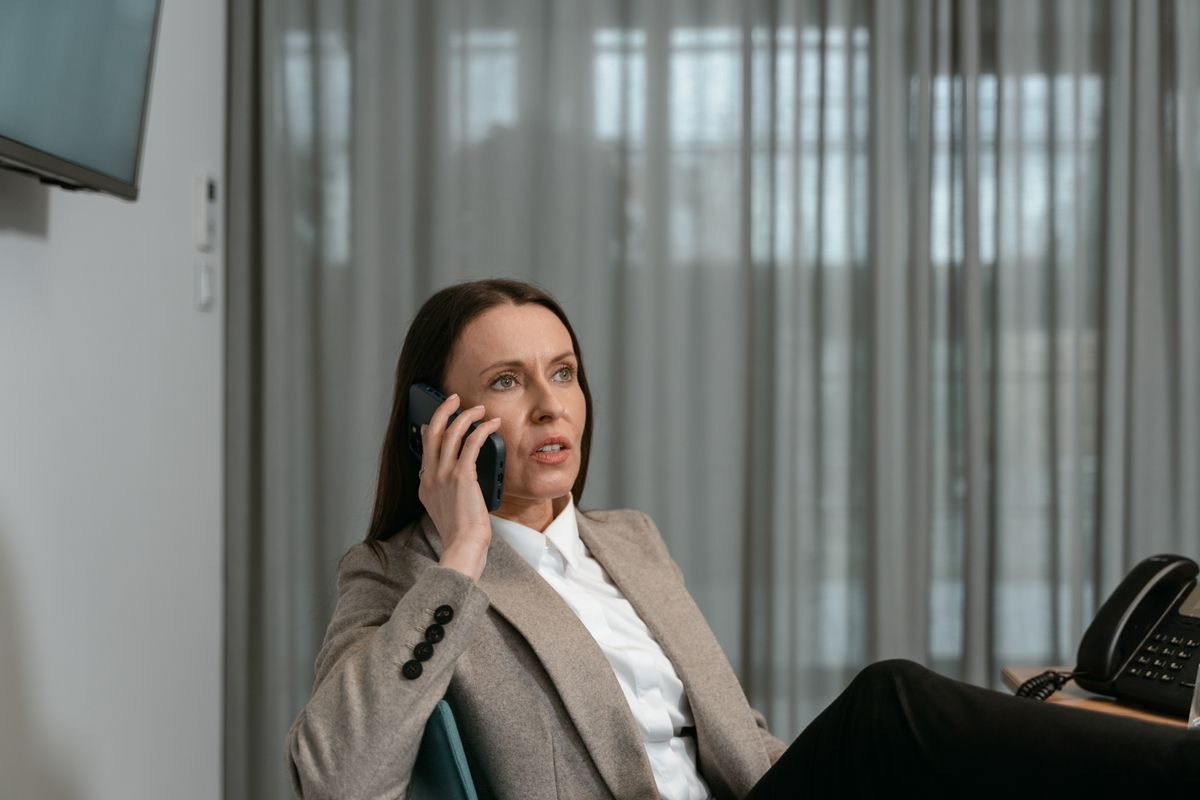 A professional holding a phone to her ear in an office