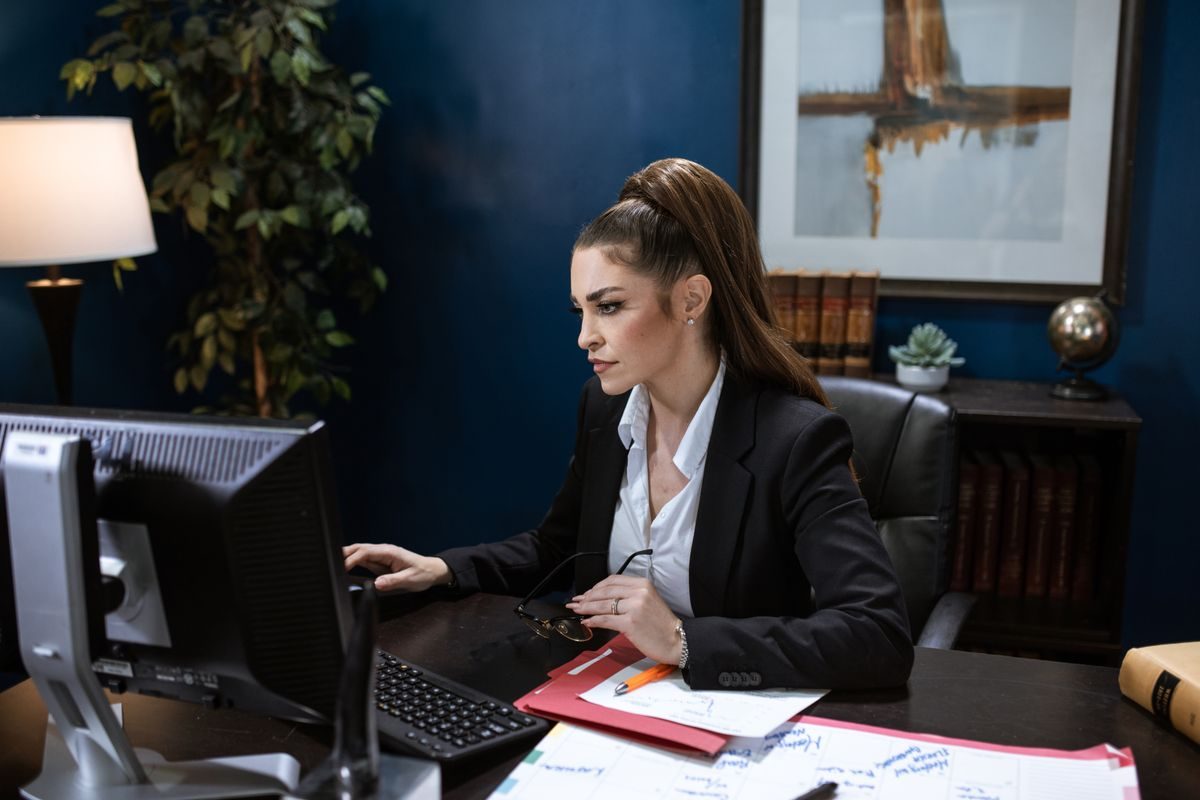 A professional working at a desktop computer in an office